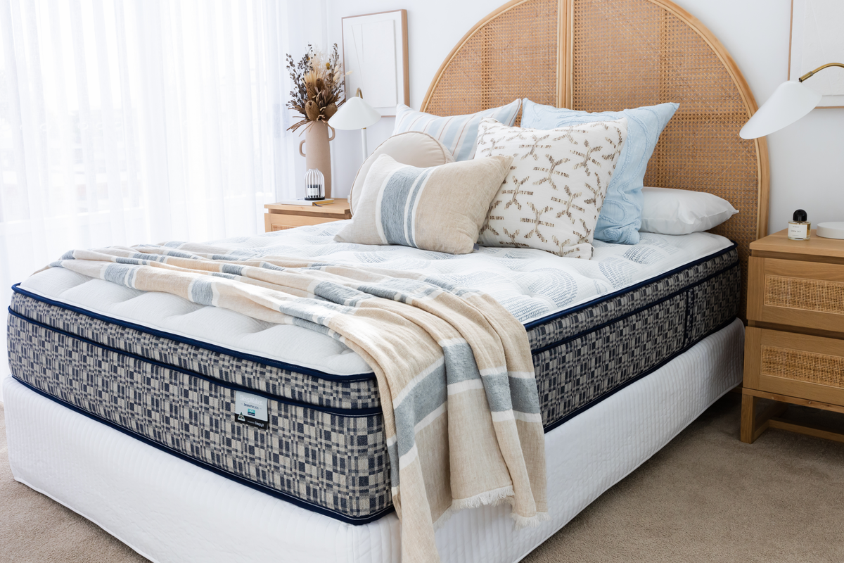 SleepMaker ACA mattress with blankets and pillows in a bedroom setting