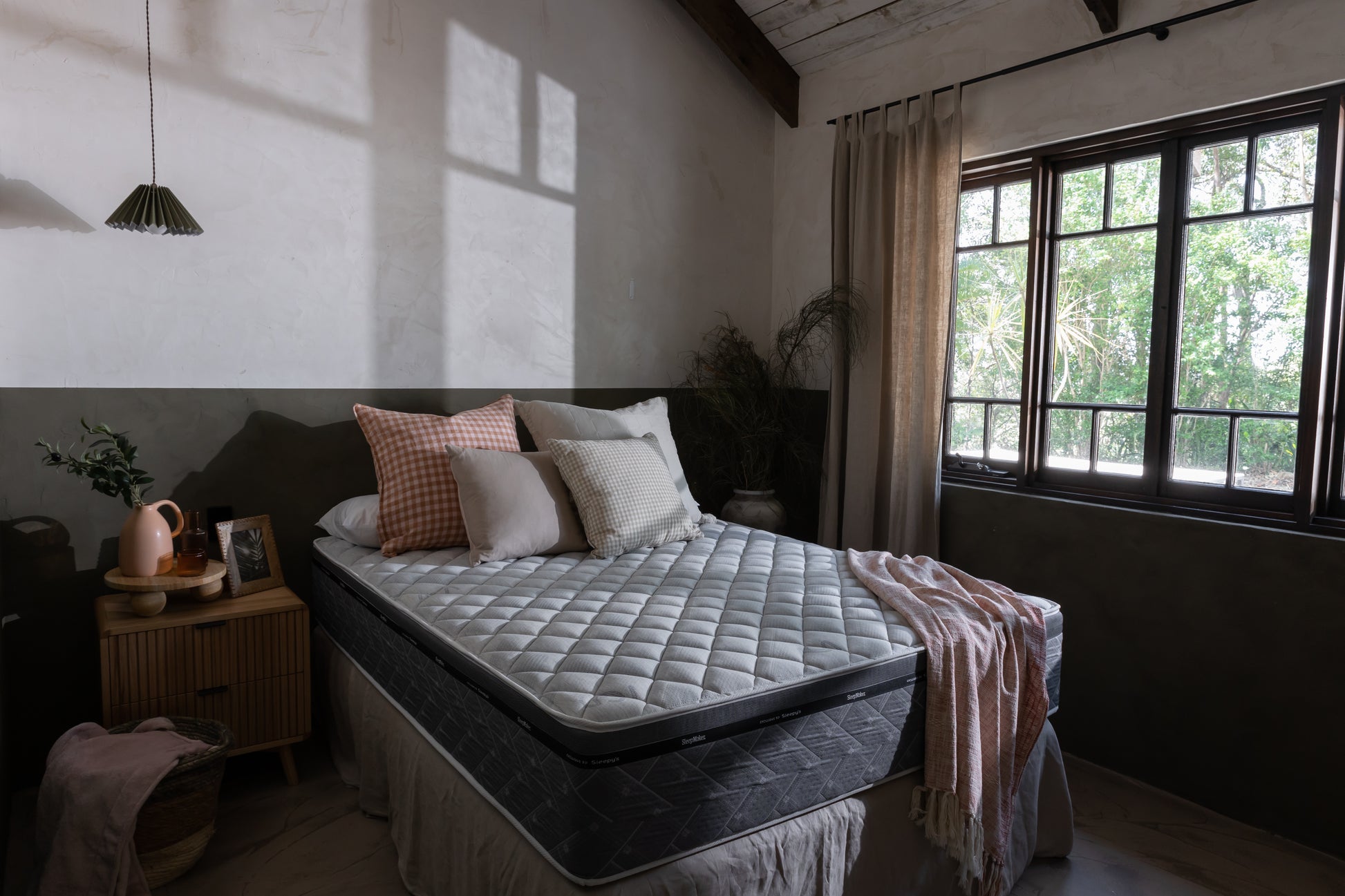SleepMaker ACA mattress with blankets and pillows in a bedroom setting