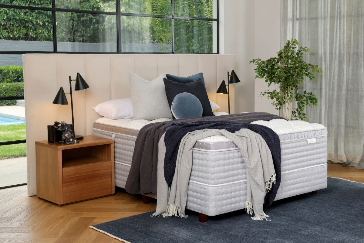 SleepMaker Cocoon mattress with blankets and pillows in a bedroom setting