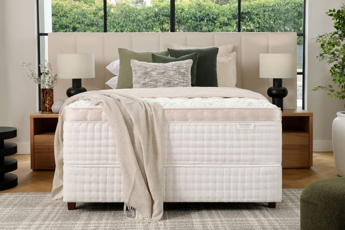 SleepMaker Cocoon mattress with blankets and pillows in a bedroom setting