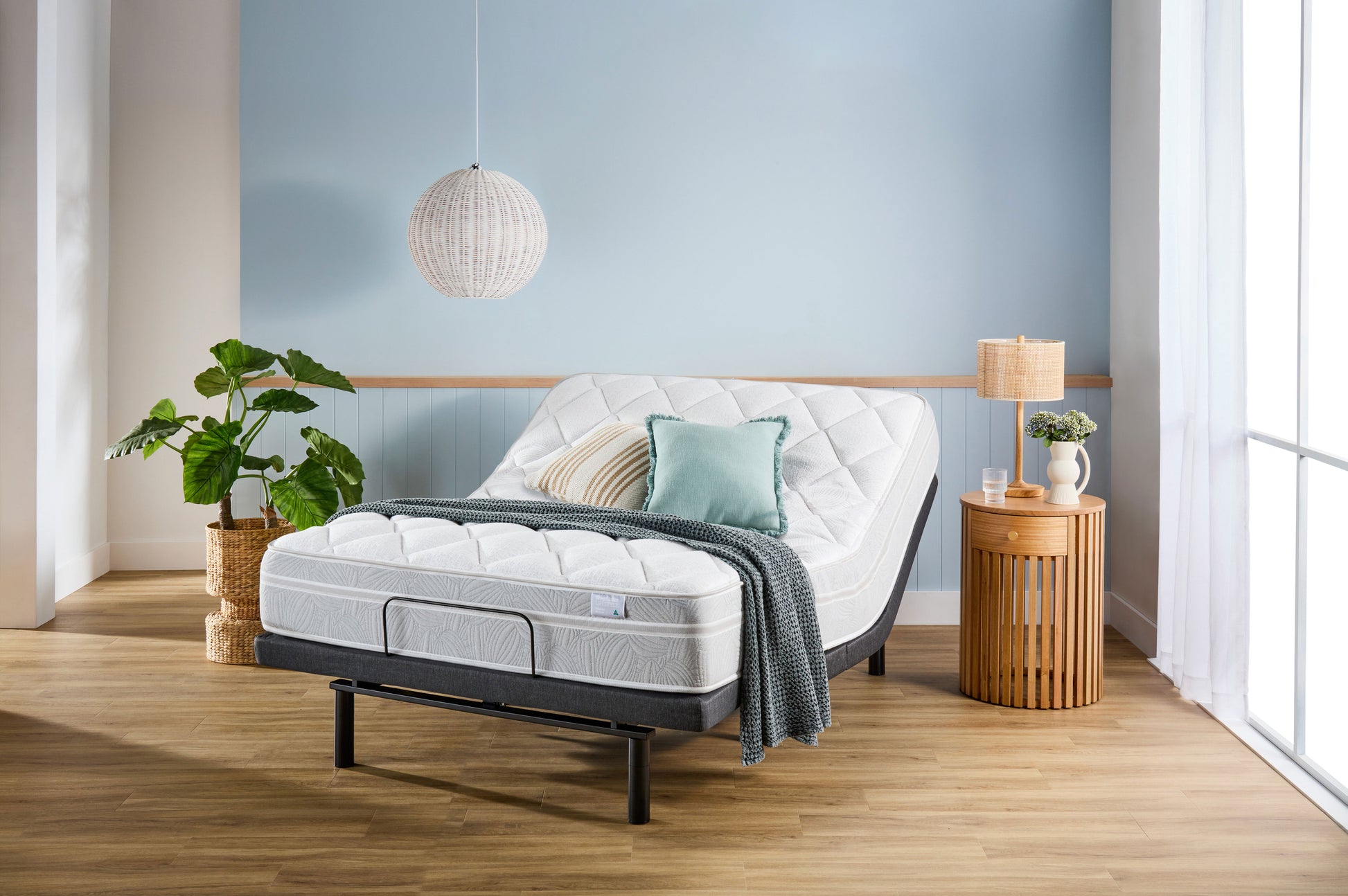 SleepMaker Lifestyle mattress with blankets and pillows in a bedroom setting