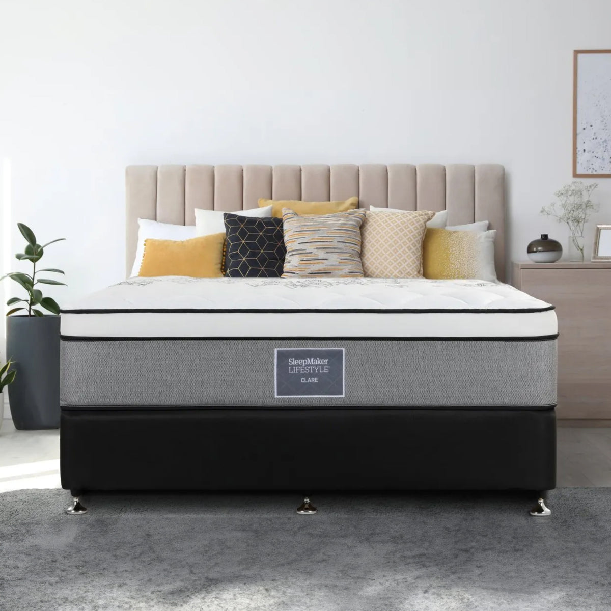 SleepMaker Lifestyle mattress with blankets and pillows in a bedroom setting