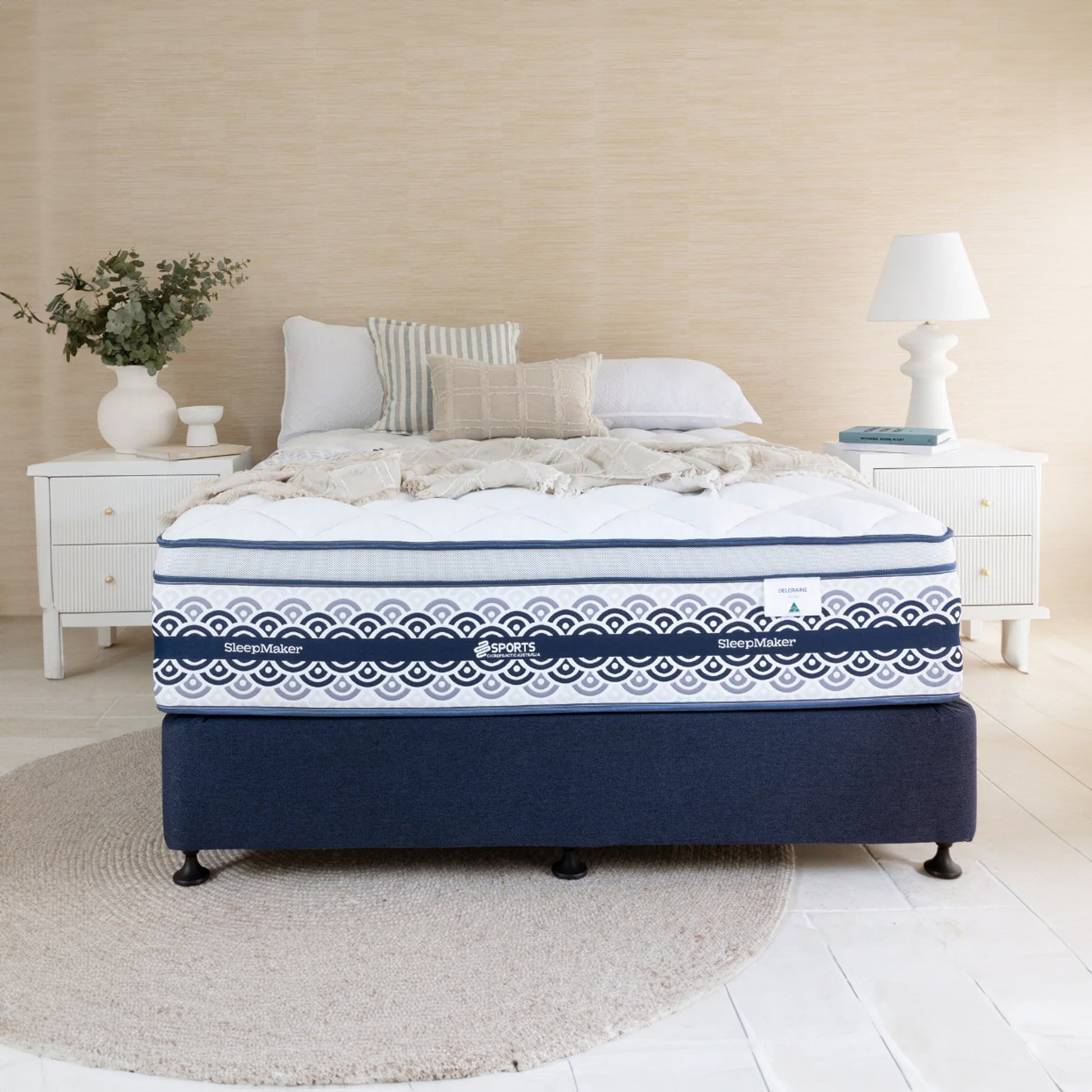 SleepMaker Miracoil mattress with blankets and pillows in a bedroom setting