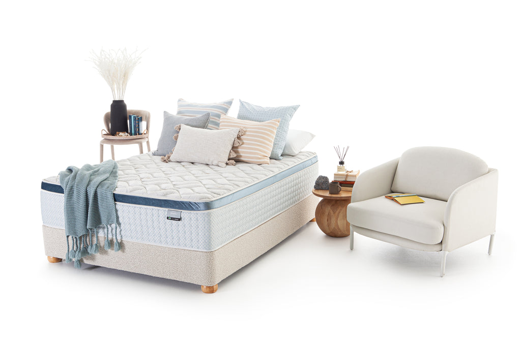 SleepMaker Bespoke mattress with blankets, pillows and furniture on a white background