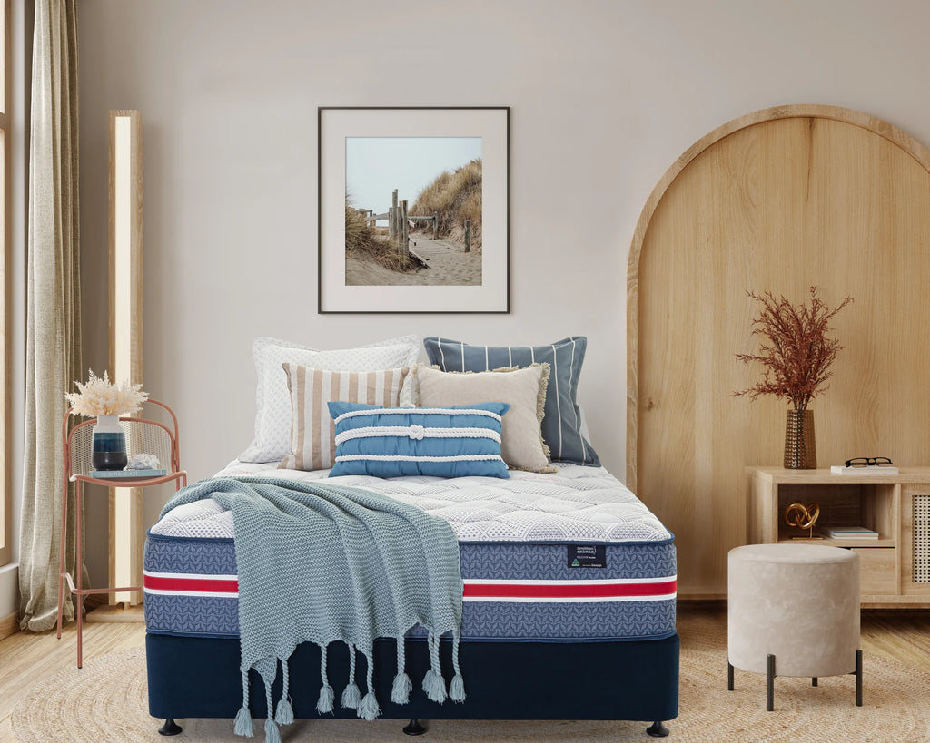 SleepMaker Sports Performance mattress with blankets and pillows in a bedroom setting