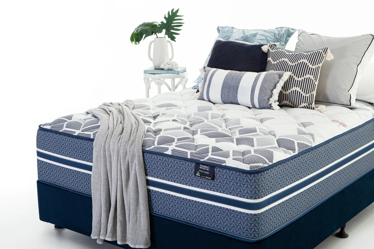 SleepMaker Sports Performance mattress with blankets and pillows in a bedroom setting