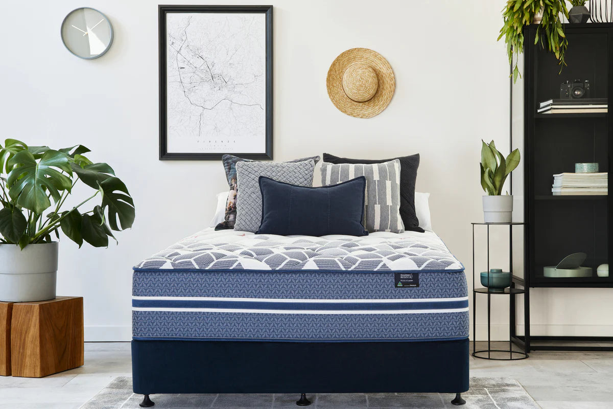 SleepMaker Sports Performance mattress with blankets and pillows in a bedroom setting