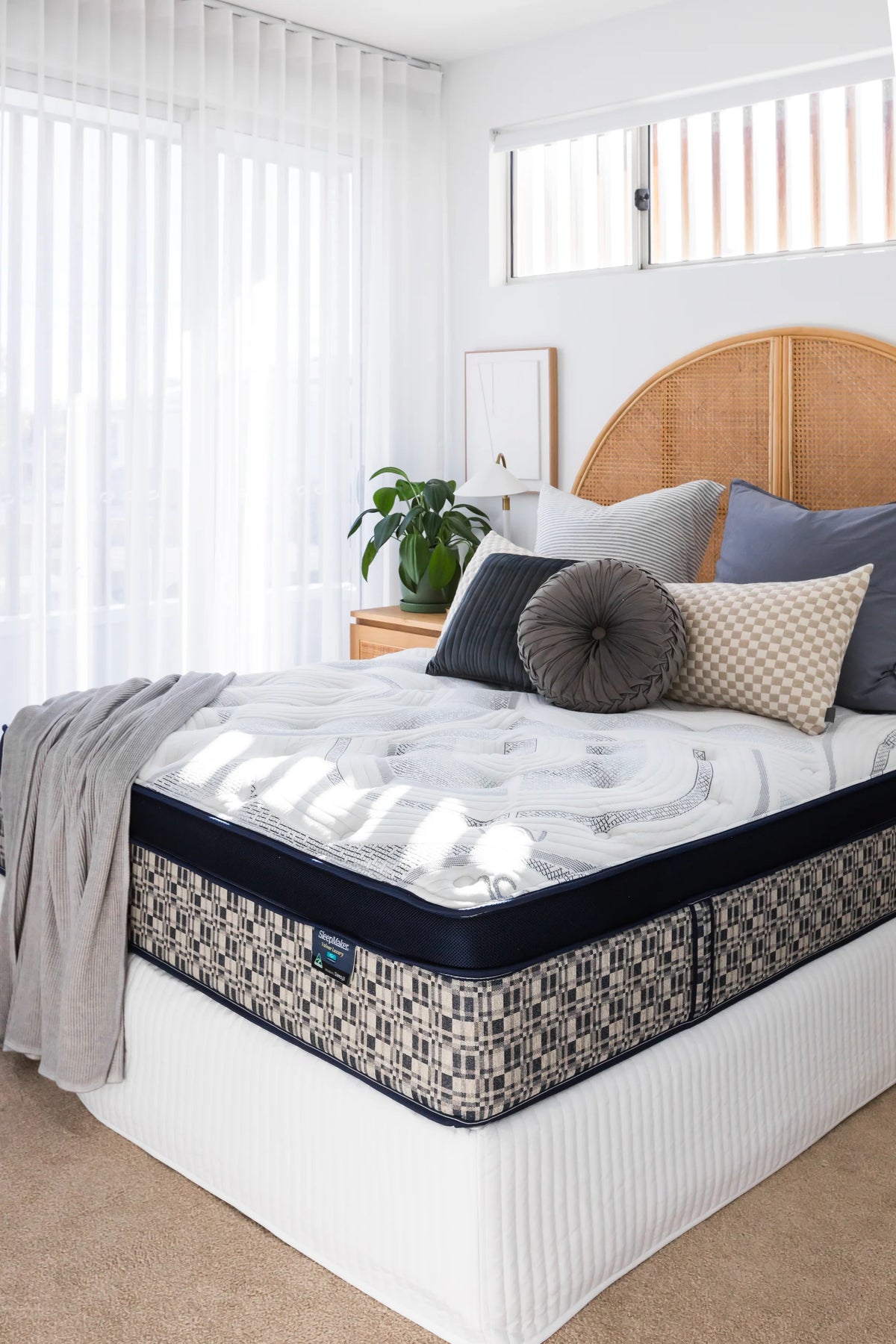 SleepMaker ACA mattress with blankets and pillows in a bedroom setting