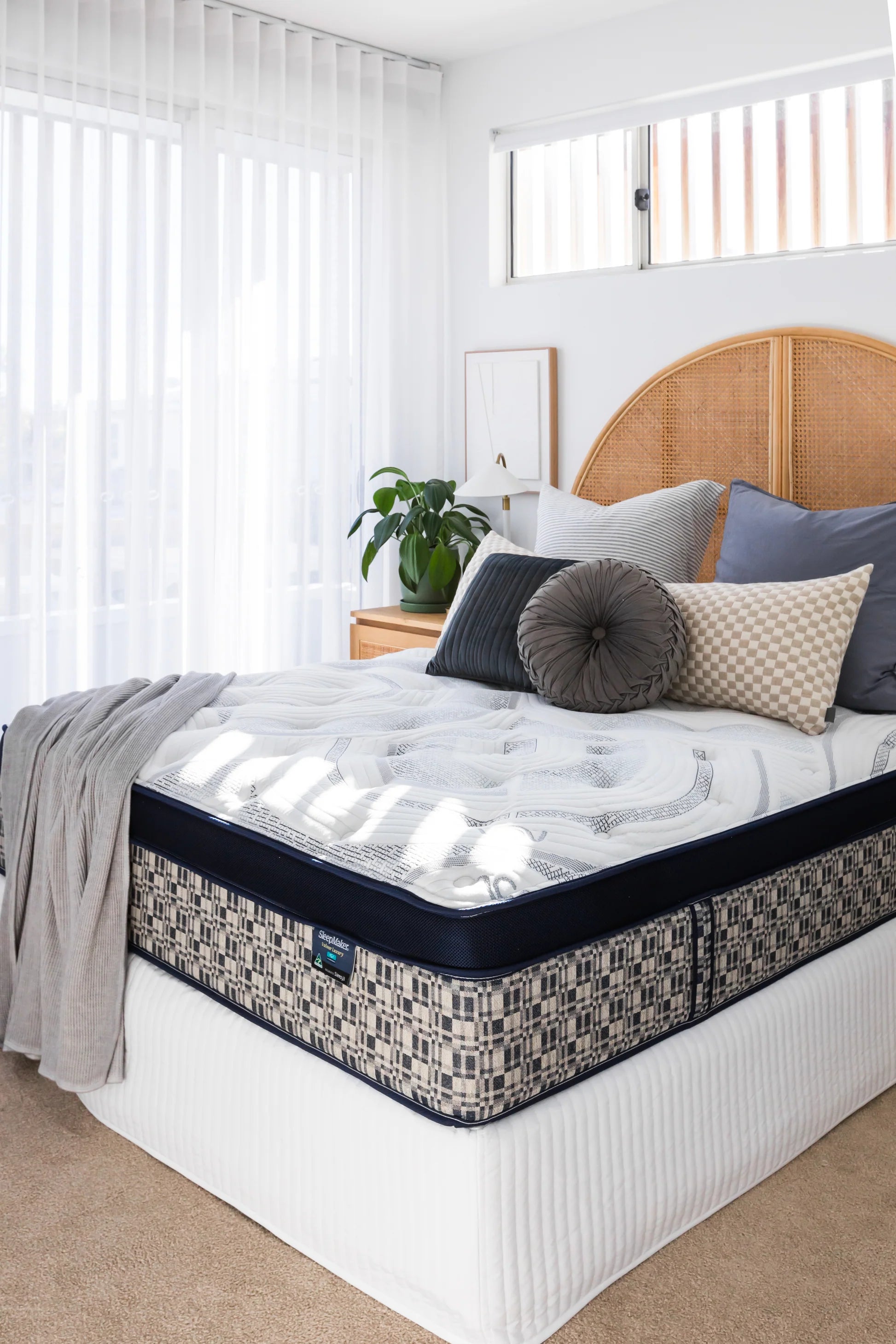 SleepMaker ACA mattress with blankets and pillows in a bedroom setting