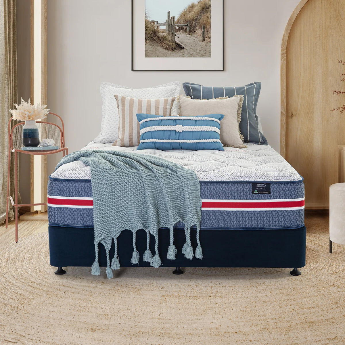 SleepMaker Sports Performance mattress with blankets and pillows in a bedroom setting
