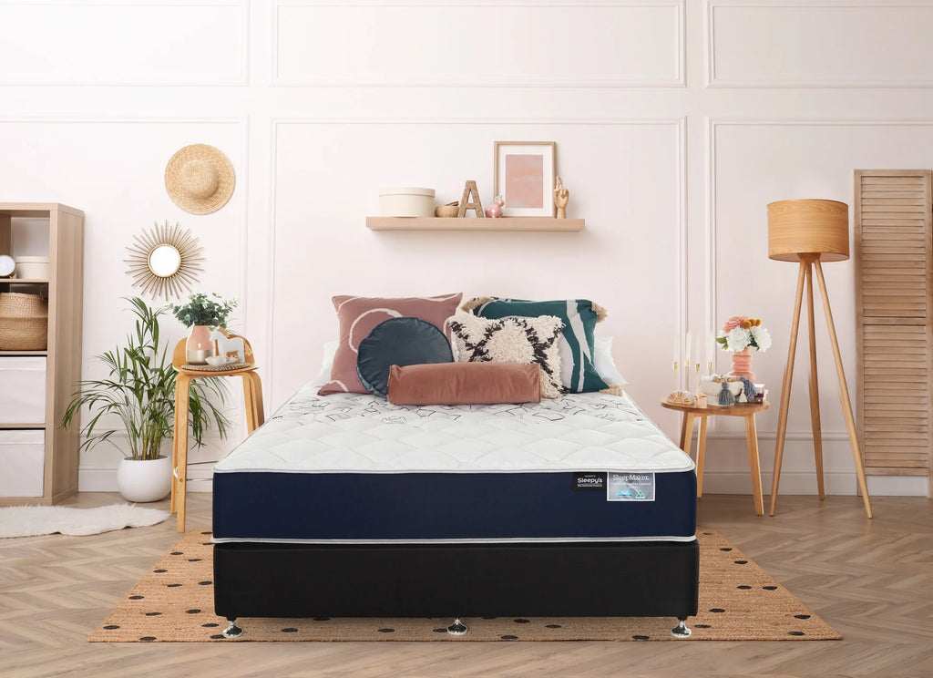 SleepMaker ACA mattress with blankets and pillows in a bedroom setting