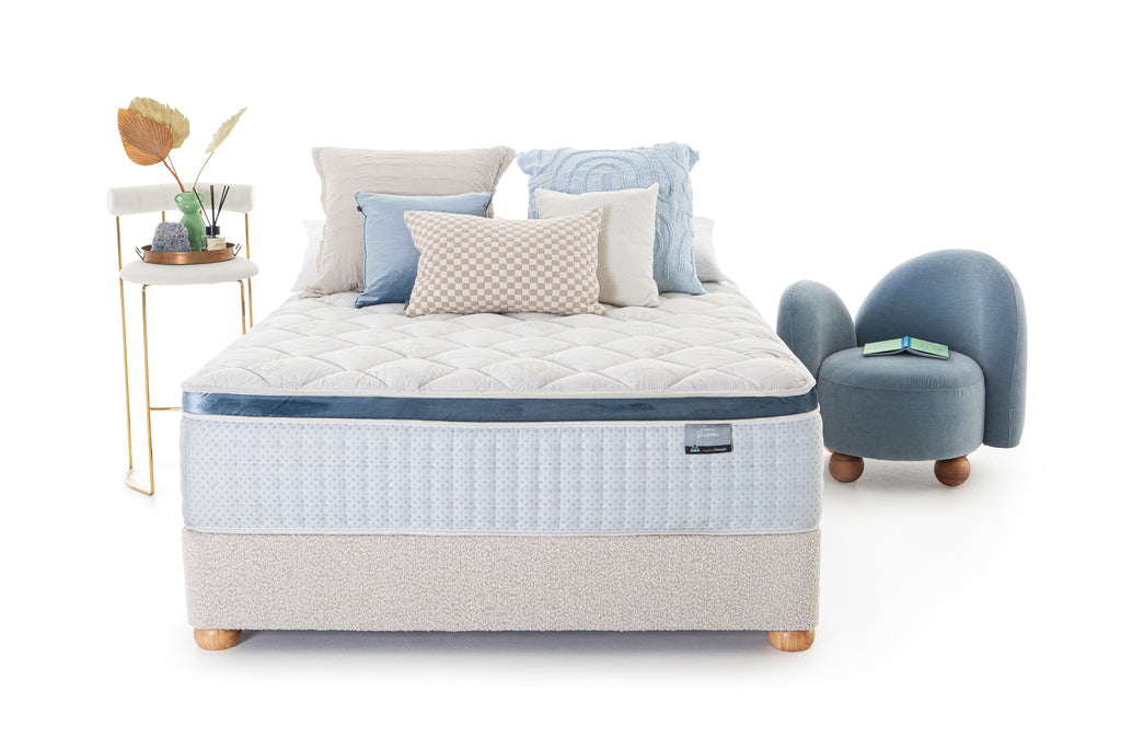 SleepMaker Bespoke mattress with pillows and furniture on a white background
