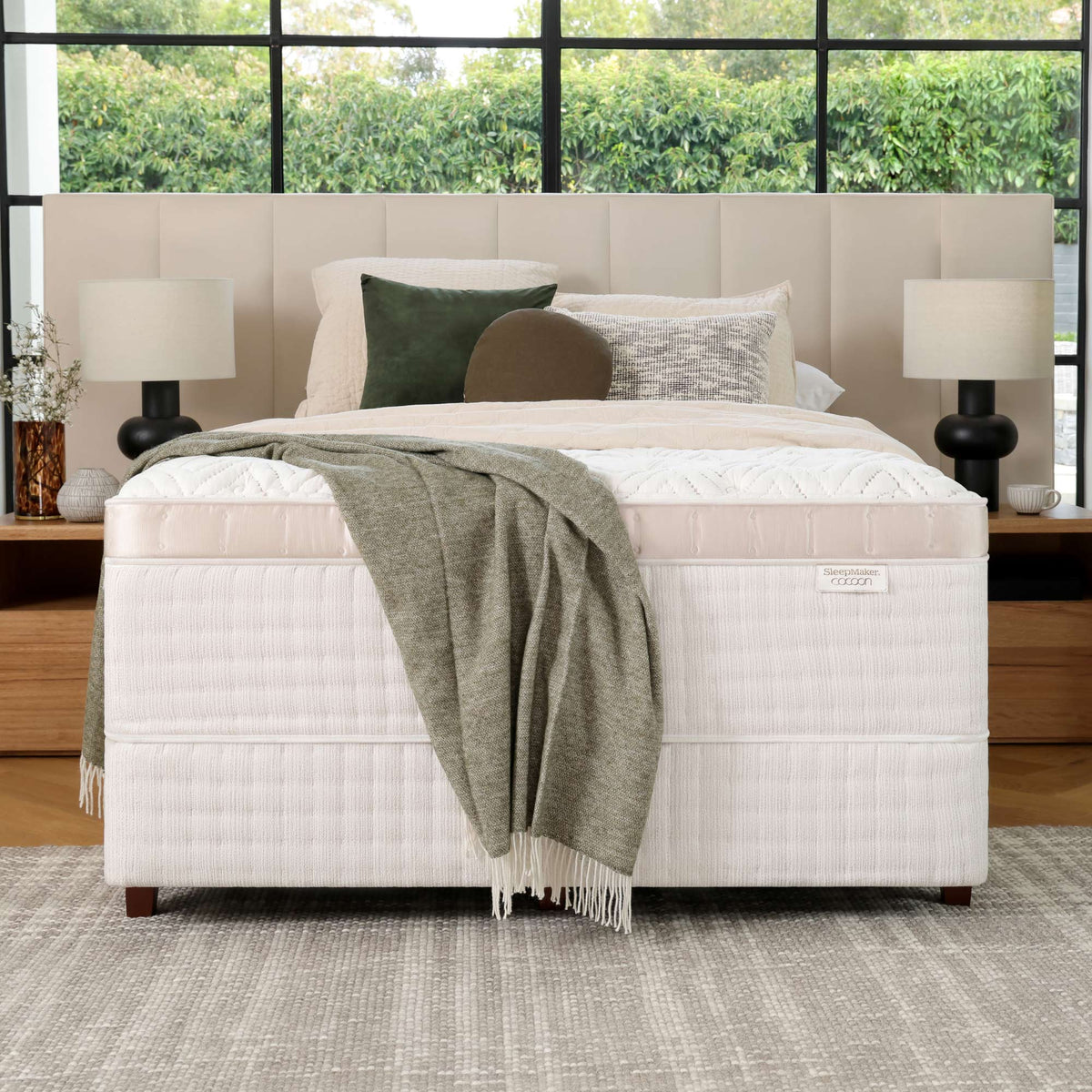 SleepMaker Cocoon mattress with blankets and pillows in a bedroom setting