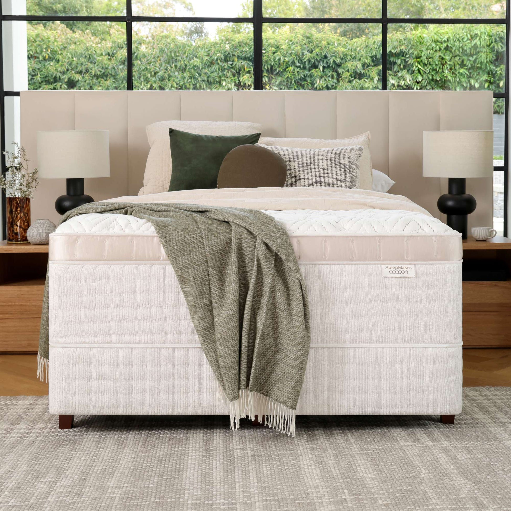 SleepMaker Cocoon mattress with blankets and pillows in a bedroom setting