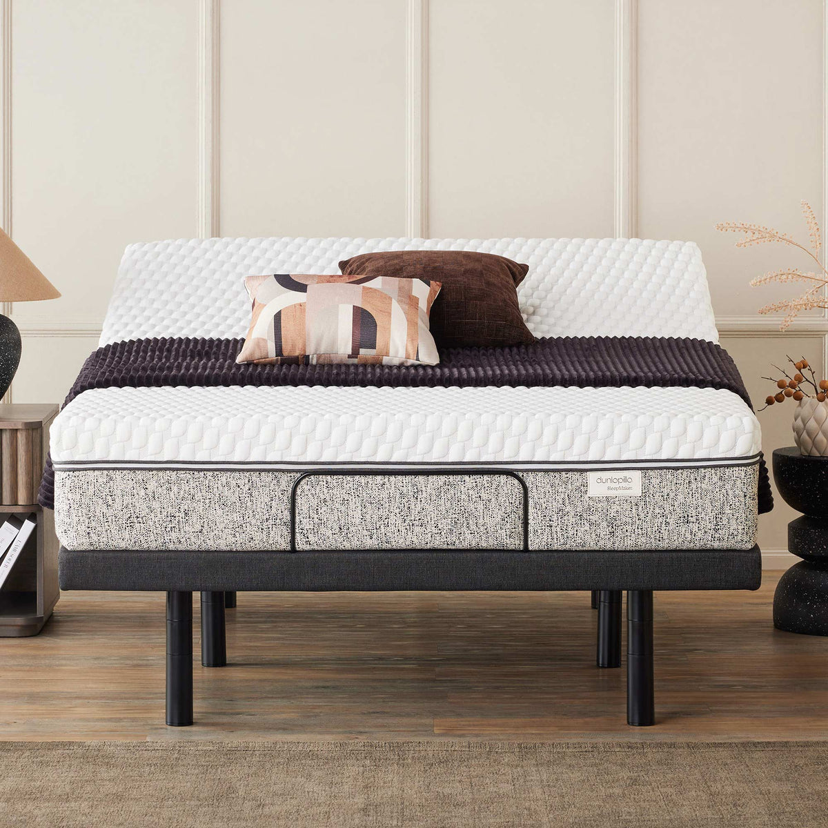 A Dunlopillo by SleepMaker mattress sitting on an adjustable bed frame in a bedroom setting