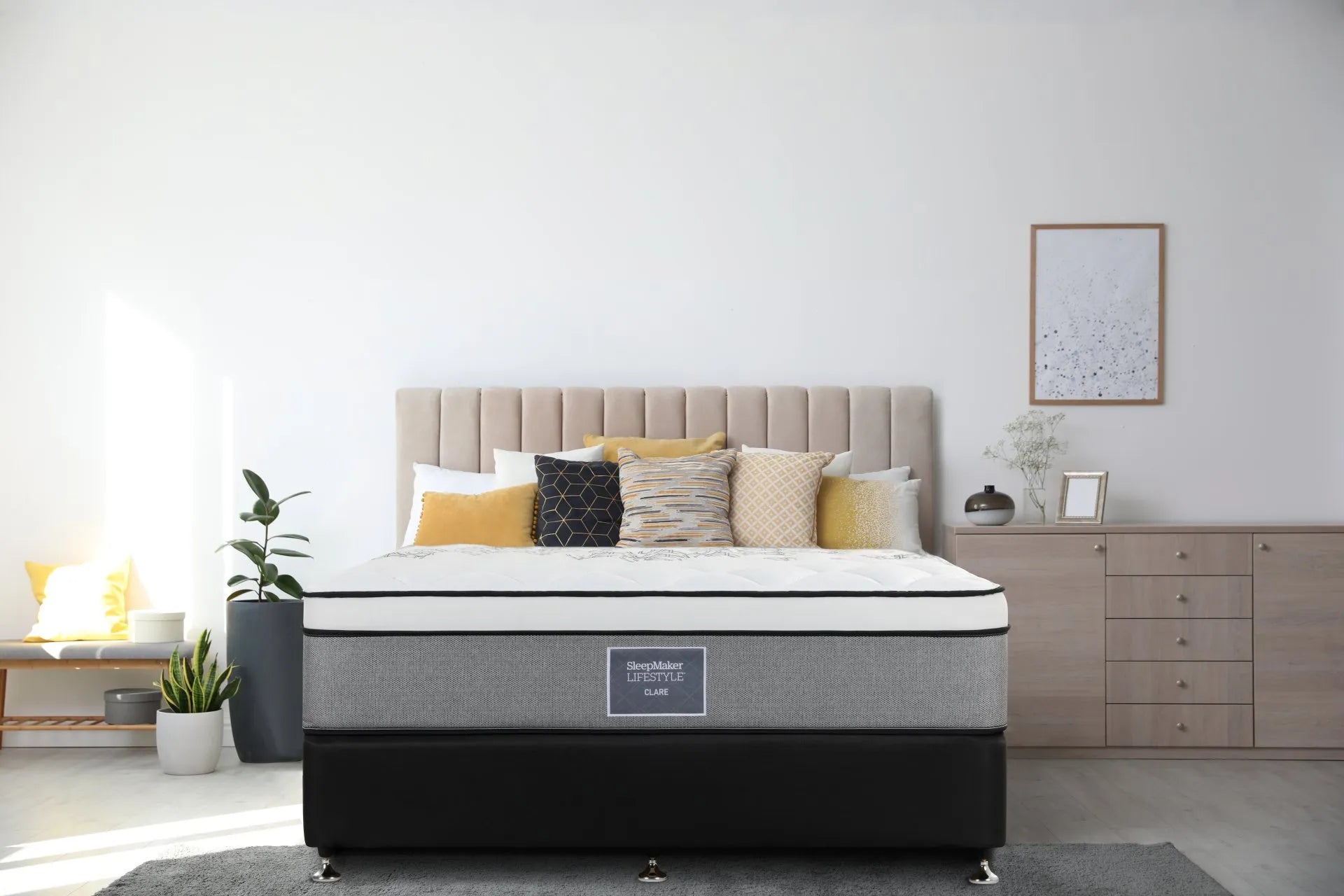 SleepMaker Lifestyle mattress with blankets and pillows in a bedroom setting