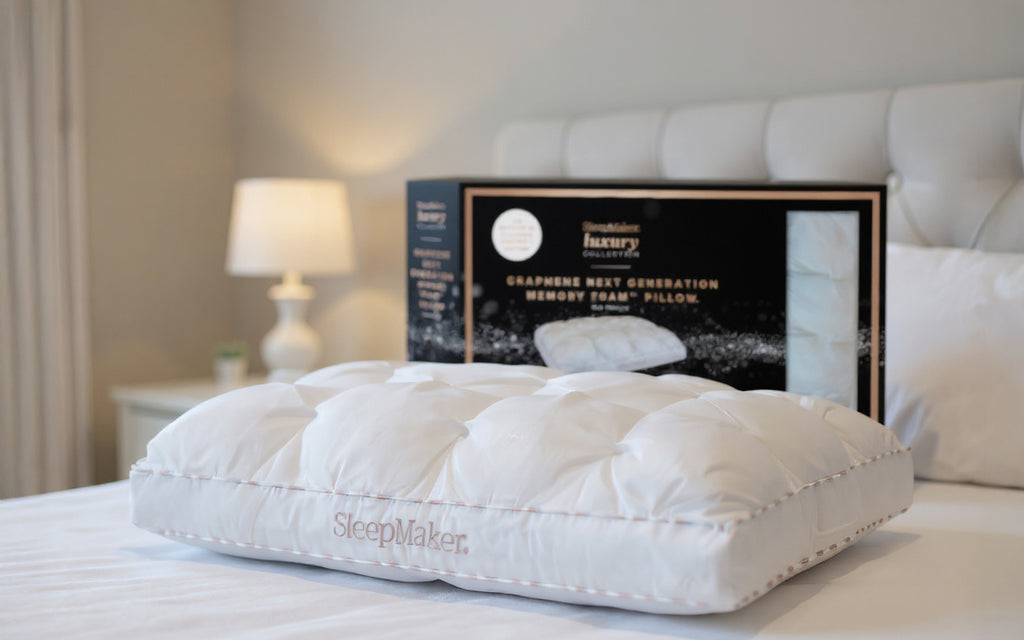 SleepMaker Luxury pillow on a bed with packaging in the background