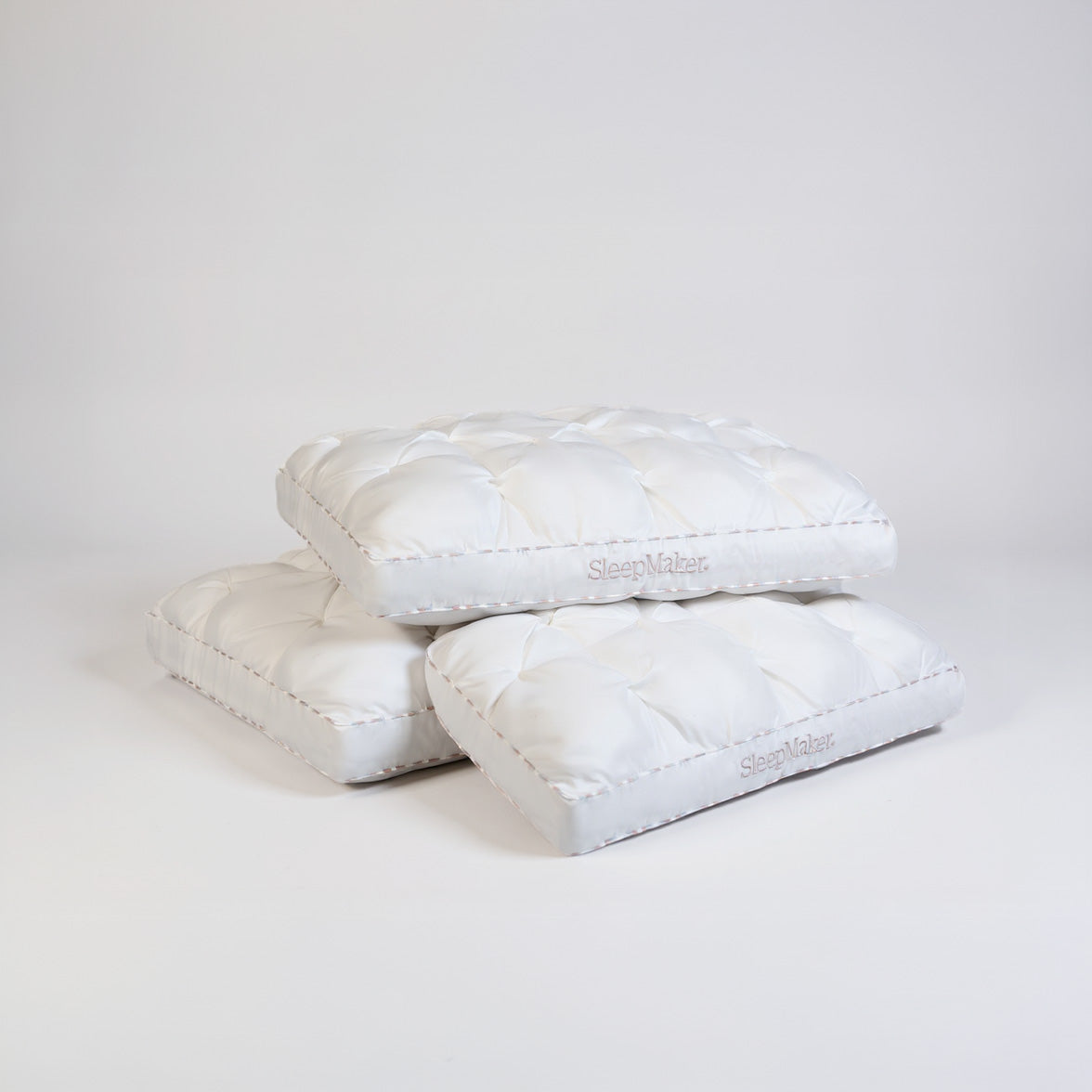 SleepMaker Luxury pillows stacked on a light gray background