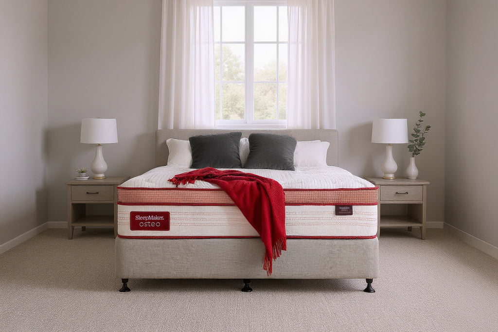 SleepMaker Osteo mattress with blankets and pillows in a bedroom setting