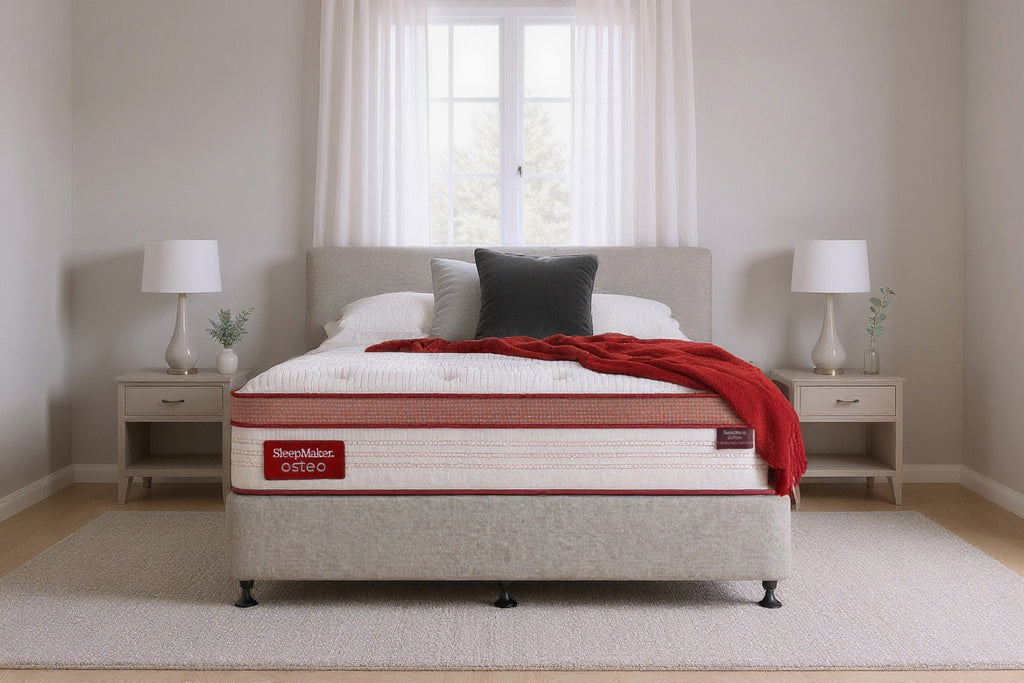 SleepMaker Osteo mattress with blankets and pillows in a bedroom setting
