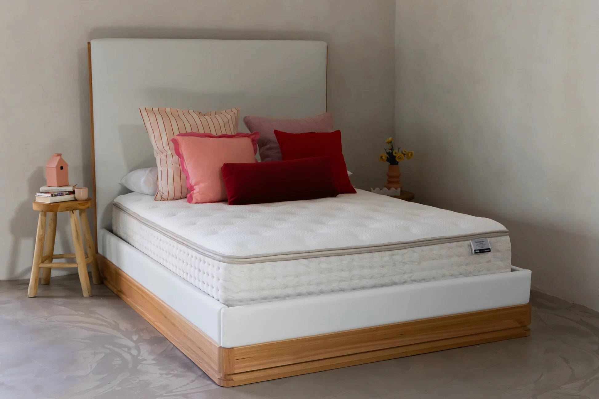 SleepMaker Lifestyle mattress with blankets and pillows in a bedroom setting