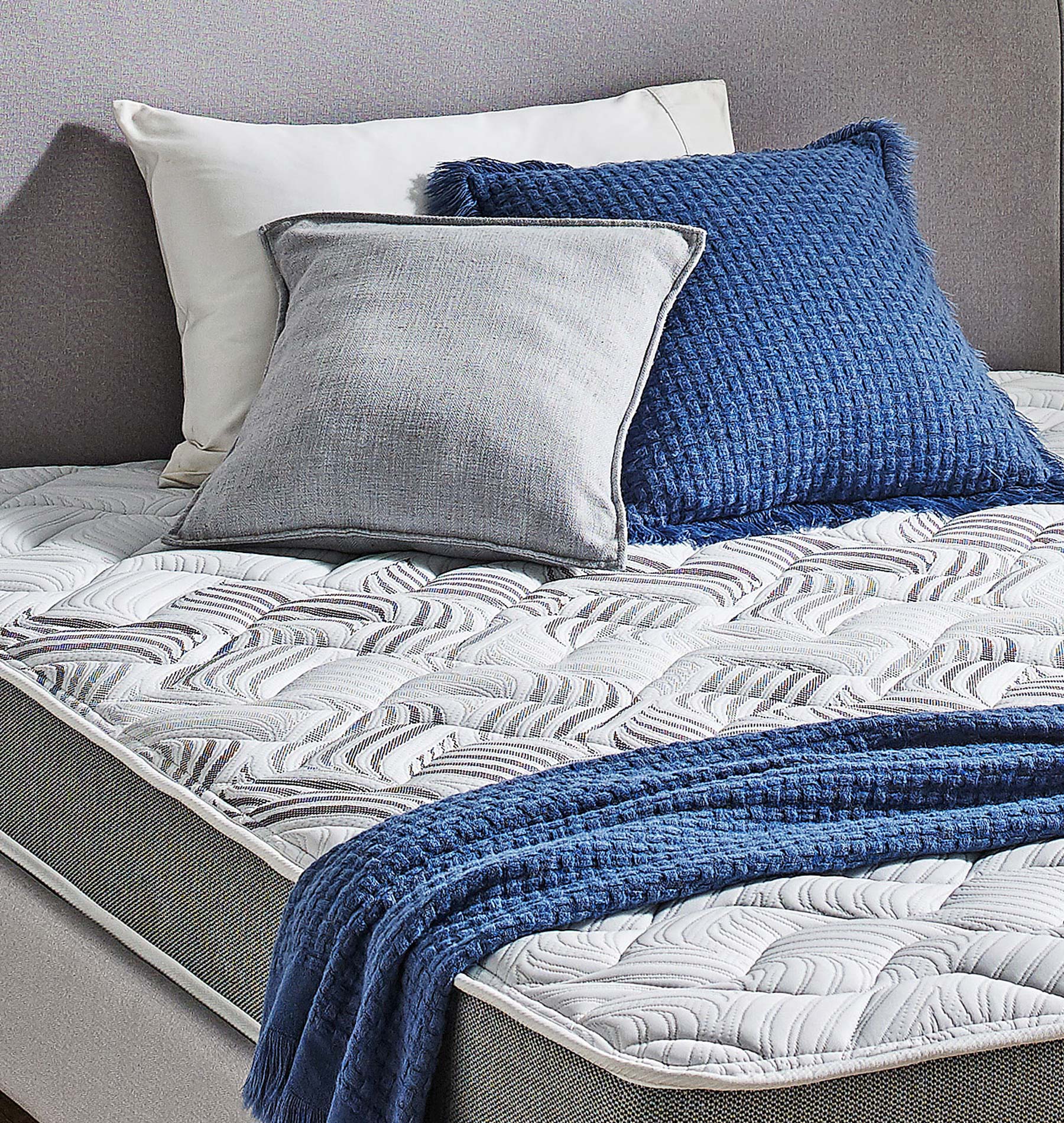 SleepMaker Elements mattress with blankets and pillows in a bedroom setting