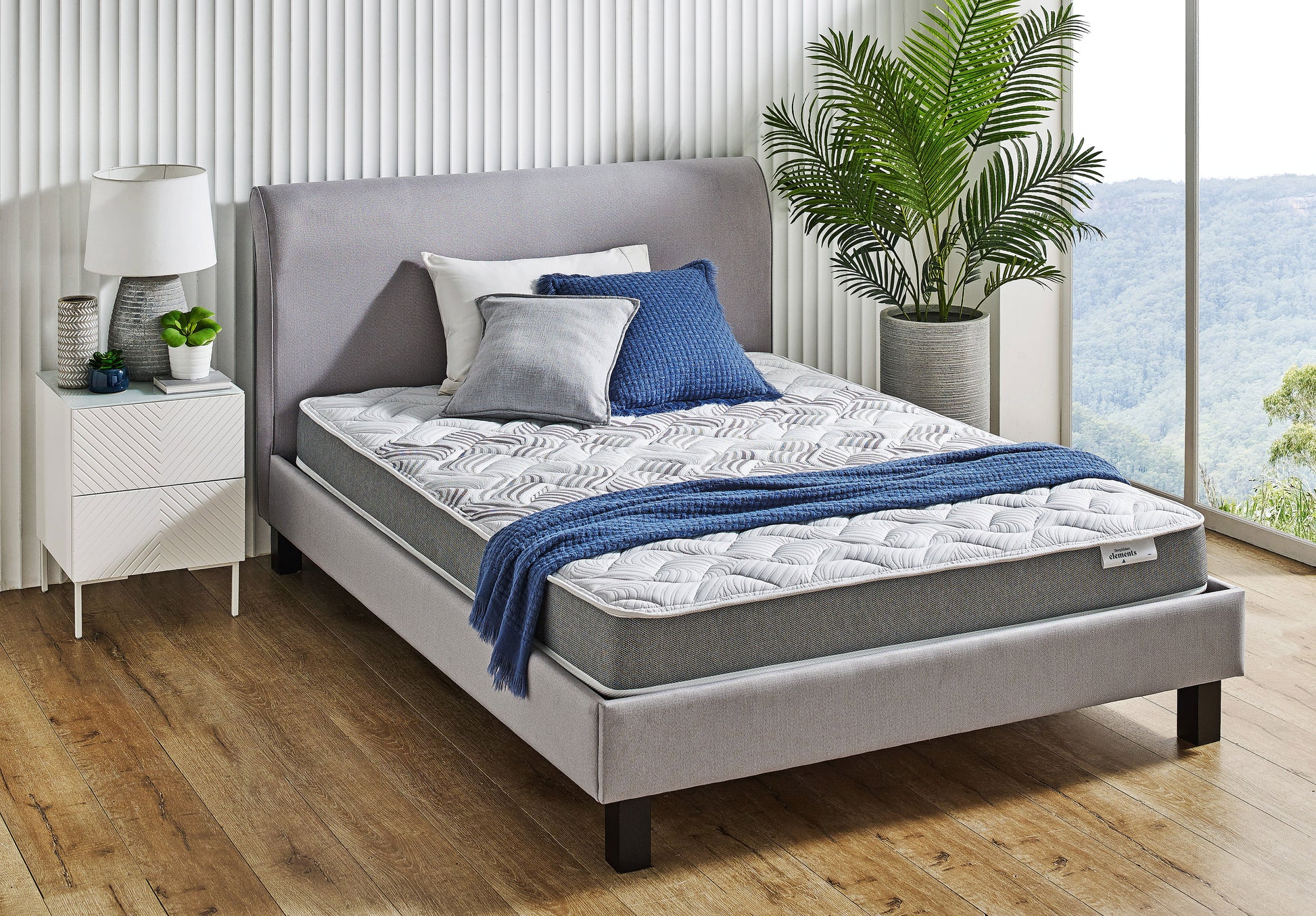 SleepMaker Elements mattress with blankets and pillows in a bedroom setting