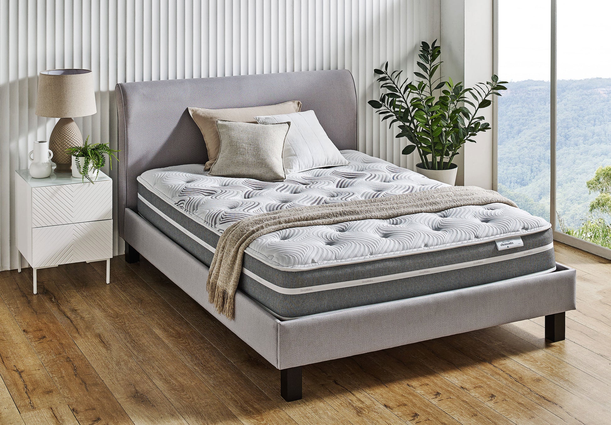 SleepMaker Elements mattress with blankets and pillows in a bedroom setting