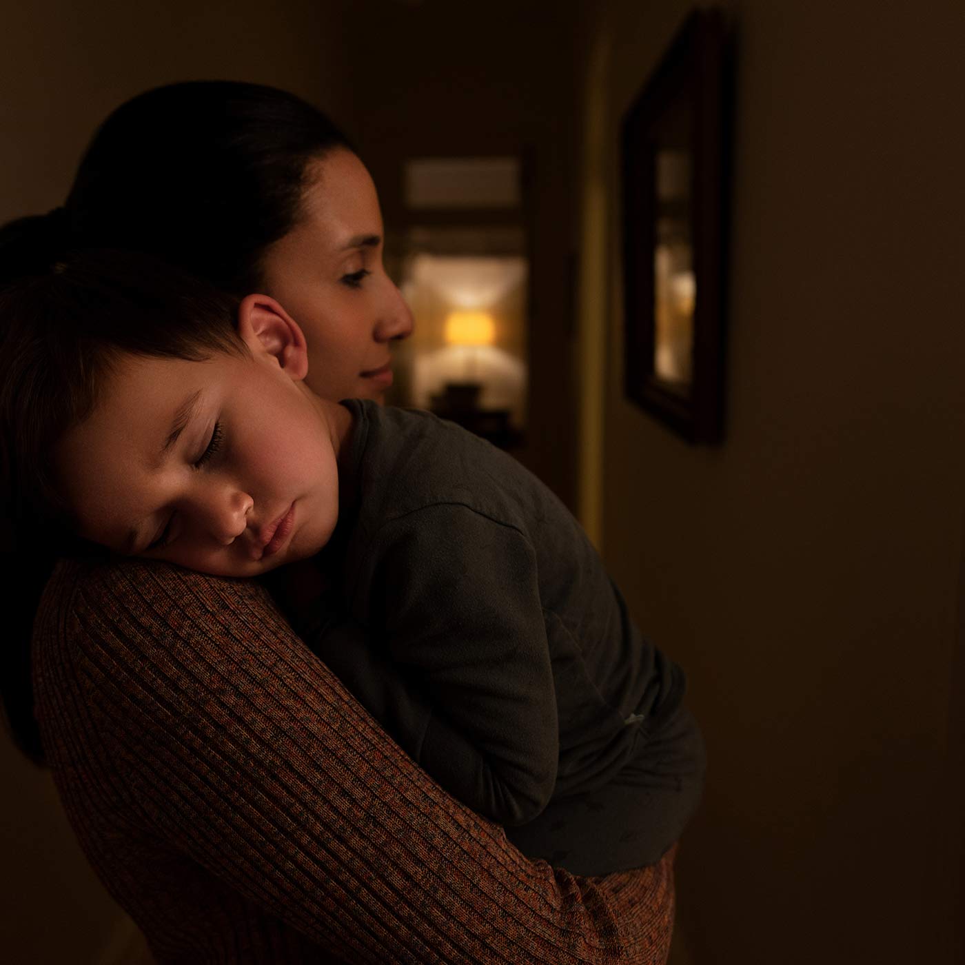 Woman embracing a child in a dimly lit room